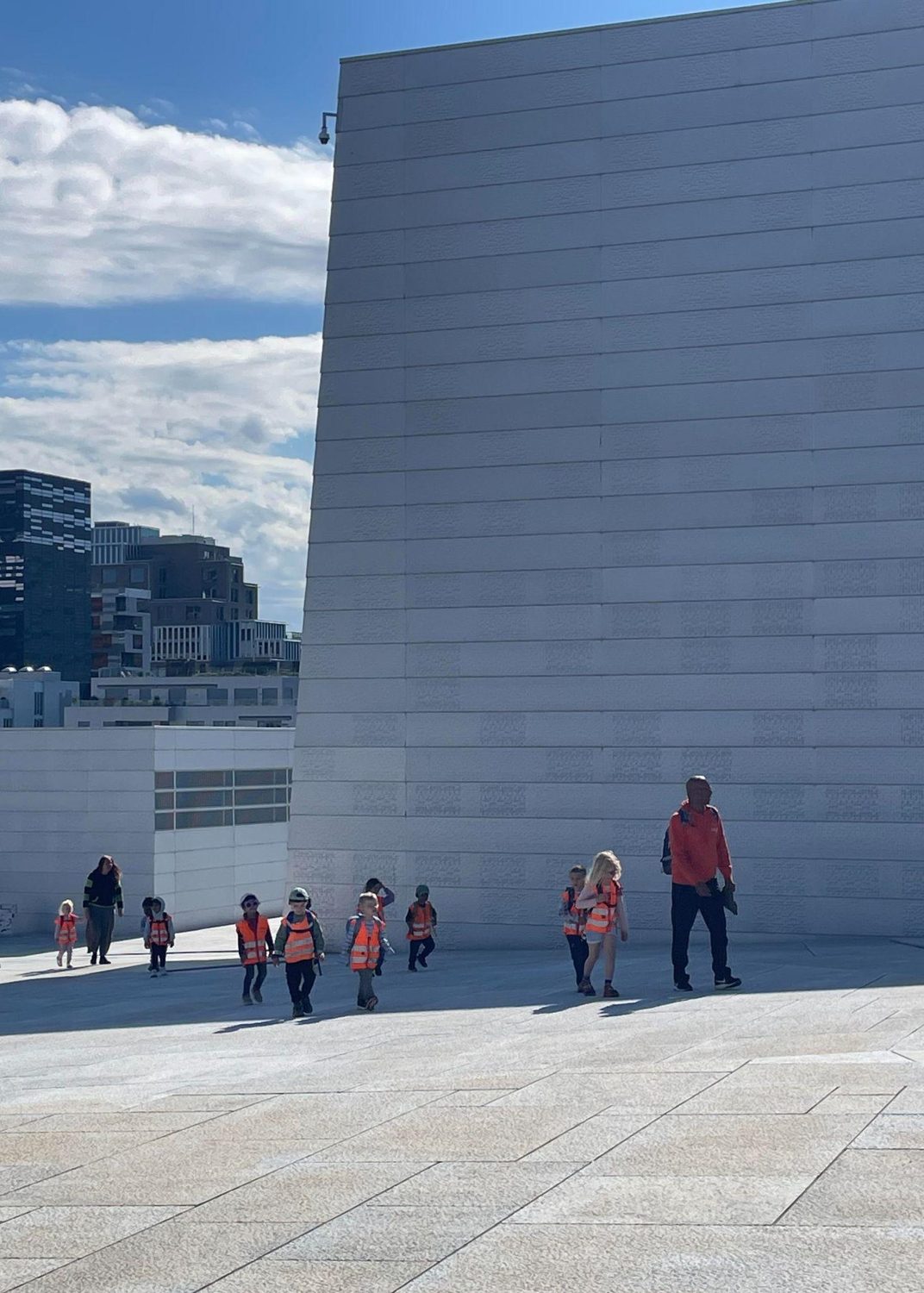 Visitors walking up the sloping marble roof of the Oslo Opera House